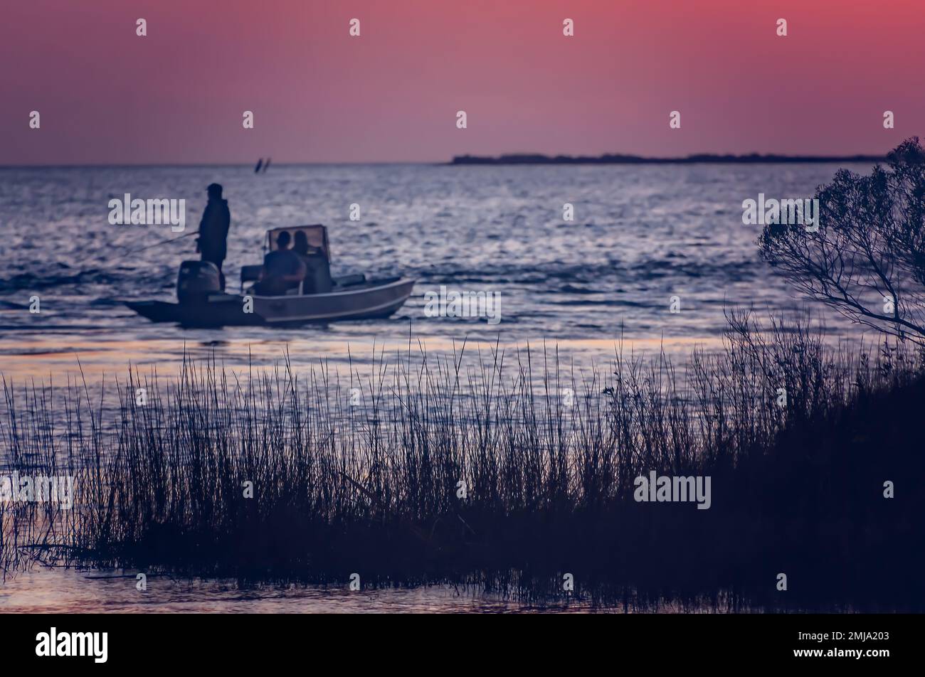 People fish as the sun sets over Heron Bay, Jan. 19, 2023, in Coden, Alabama. The Heron Bay wetlands, managed through the Forever Wild program, consis Stock Photo