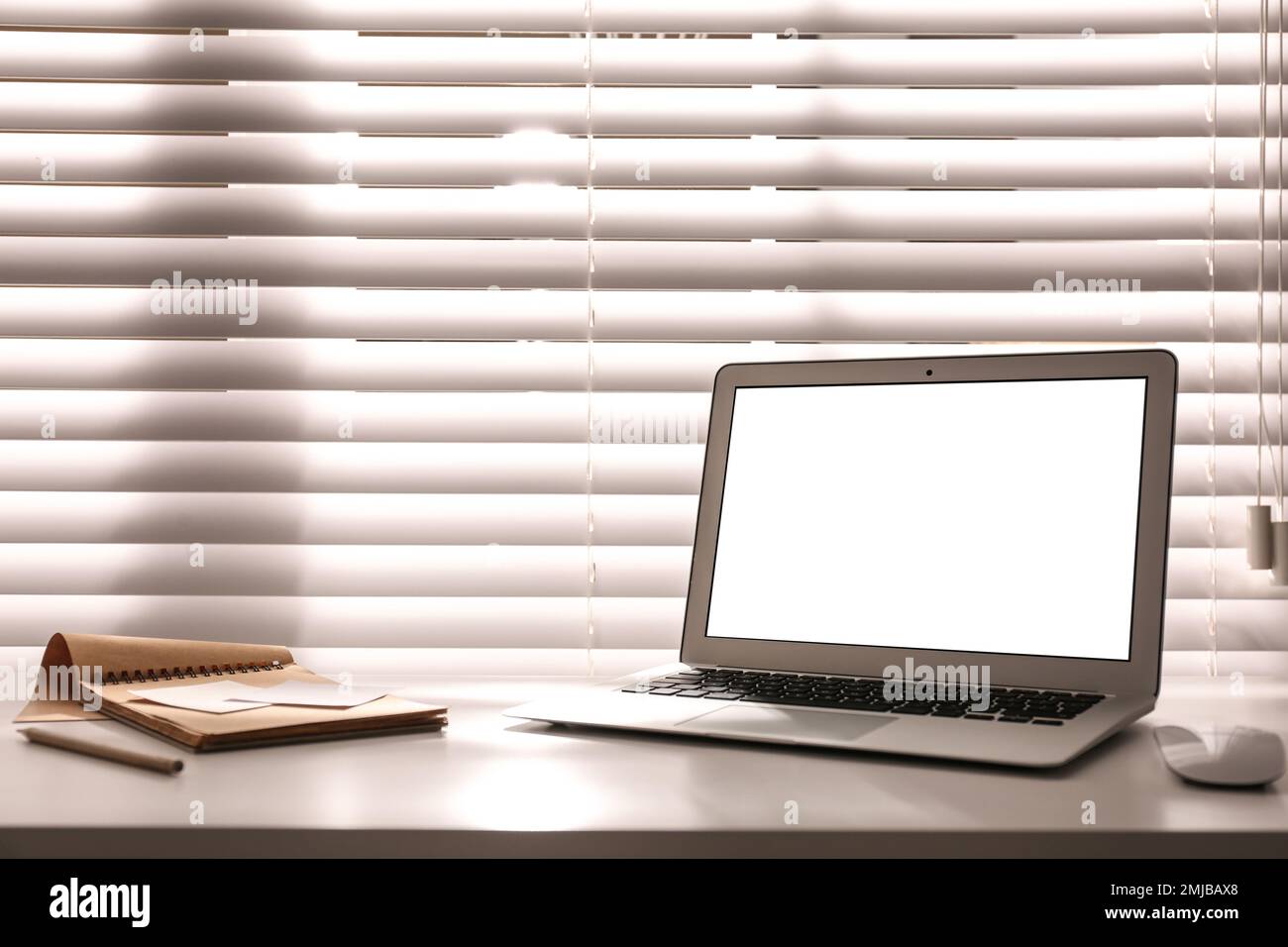 Laptop on desk near window in office. Comfortable workplace Stock Photo