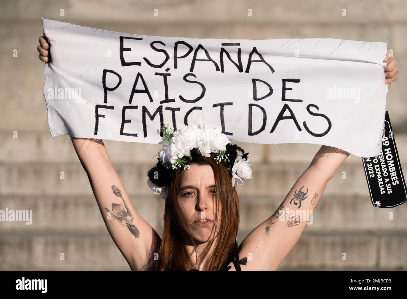 Madrid, Spain. 27th Jan, 2023. An activist raises a banner that says 'Spain is femicide' during the demonstration. FEMEN activists held a protest at the Retiro park, against the growing number of femicides committed in Spain during 2022 and the beginning of 2023. (Photo by Diego Radames/SOPA Images/Sipa USA) Credit: Sipa USA/Alamy Live News Stock Photo