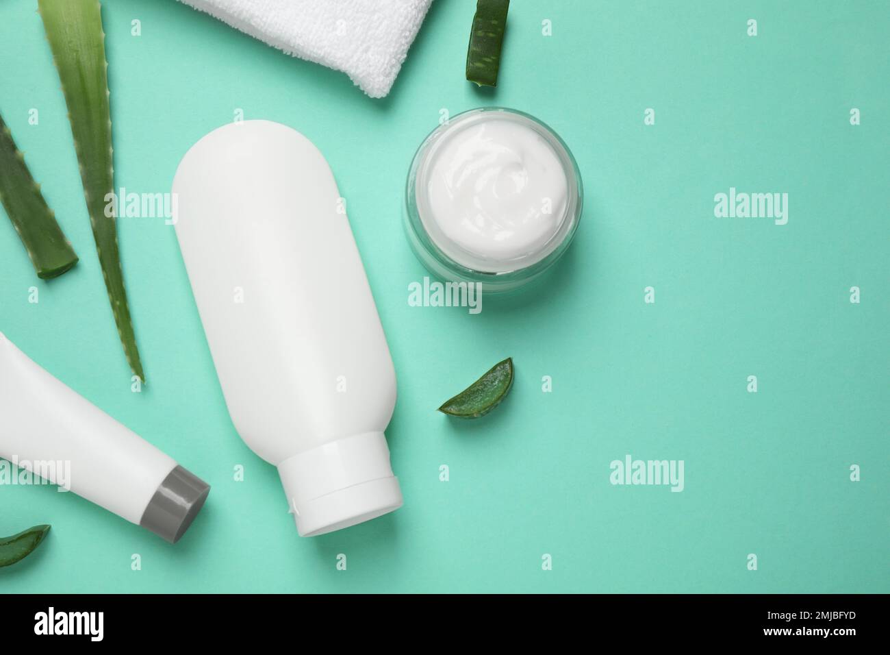 Flat lay composition with aloe vera and cosmetic products on turquoise ...