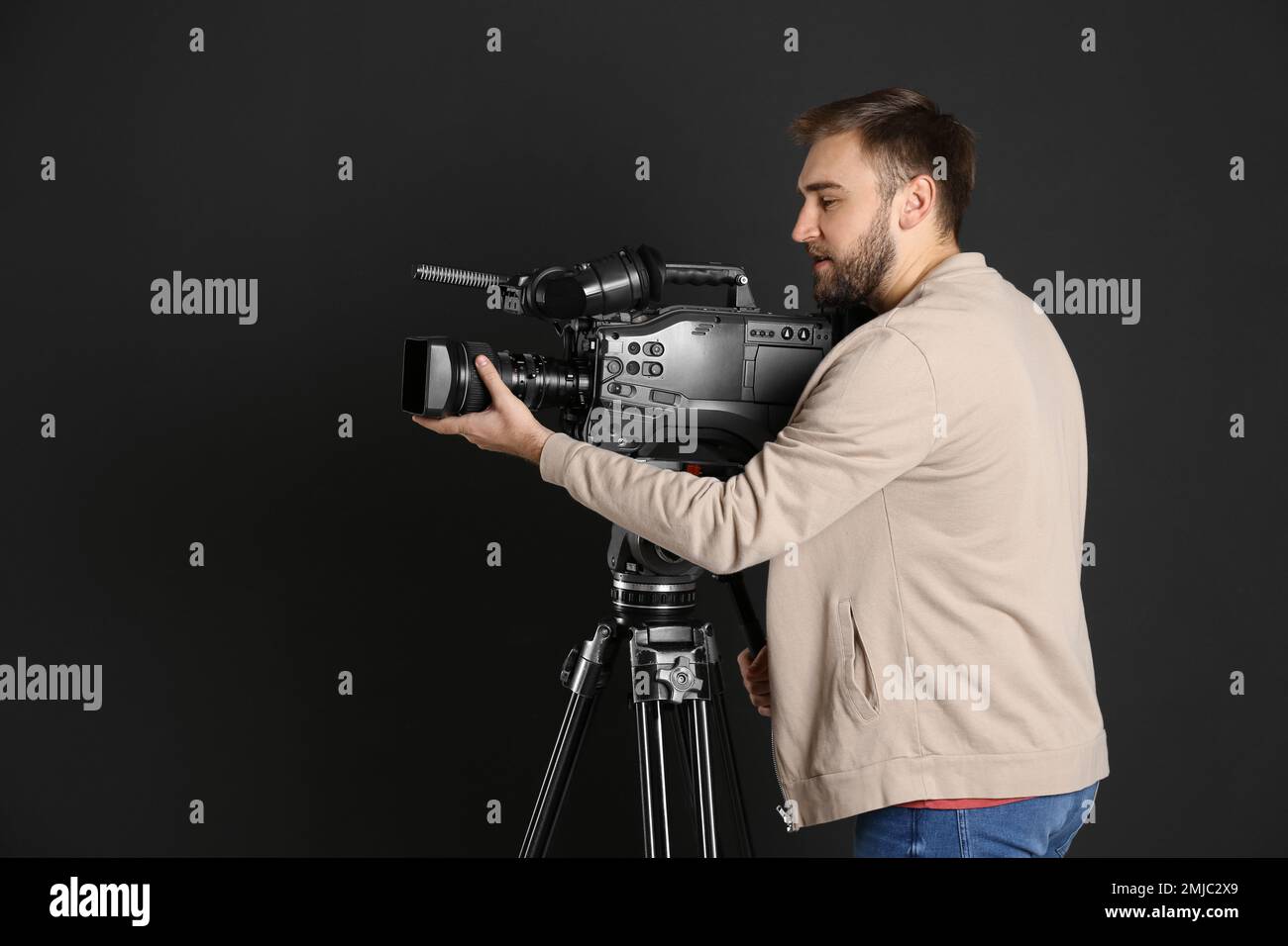 Operator with professional video camera on black background Stock Photo