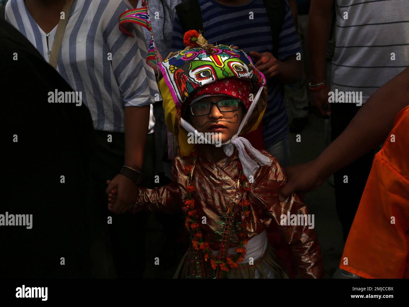 A Nepalese Hindu boy in festival attire walks in a procession along with his parents during Gai Jatra or Cow Festival in Kathmandu Nepal Friday Aug. 16 2019. Members of Nepal s Newar