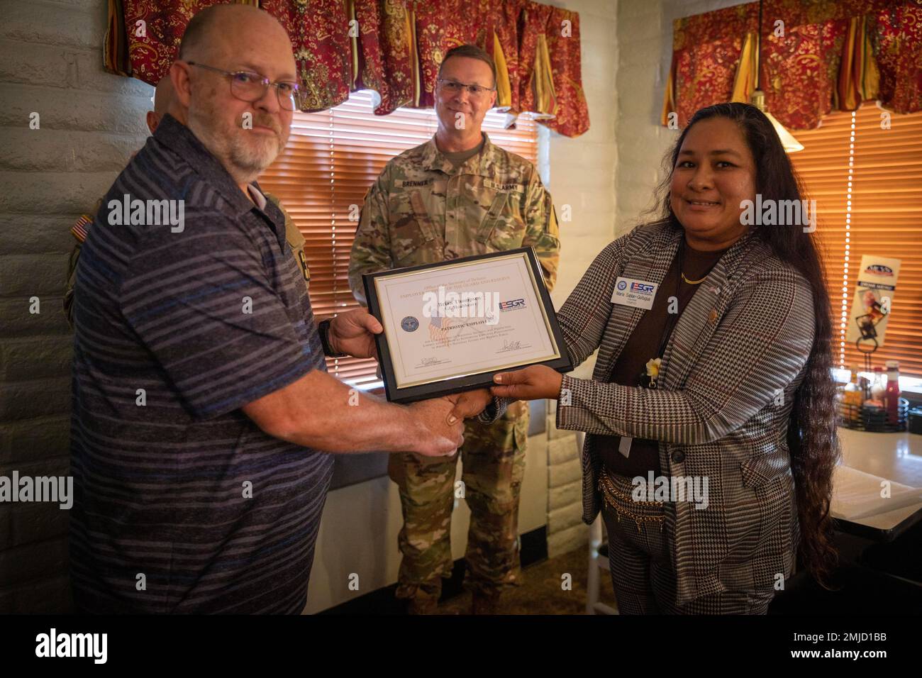 Maria Sablan-Quitugua, from the Idaho ESGR committee, presents Brian Thompson of GE Healthcare with the “Patriotic Employer” certificate on Aug. 26, 2022, in Caldwell, Idaho. Stock Photo