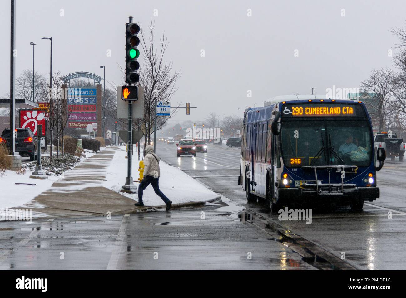 Niles, Illinois, United States - January 27, 2023: Man getting of the bus during winter storm on Touhy Ave in Niles during the first heavy snow of the Stock Photo