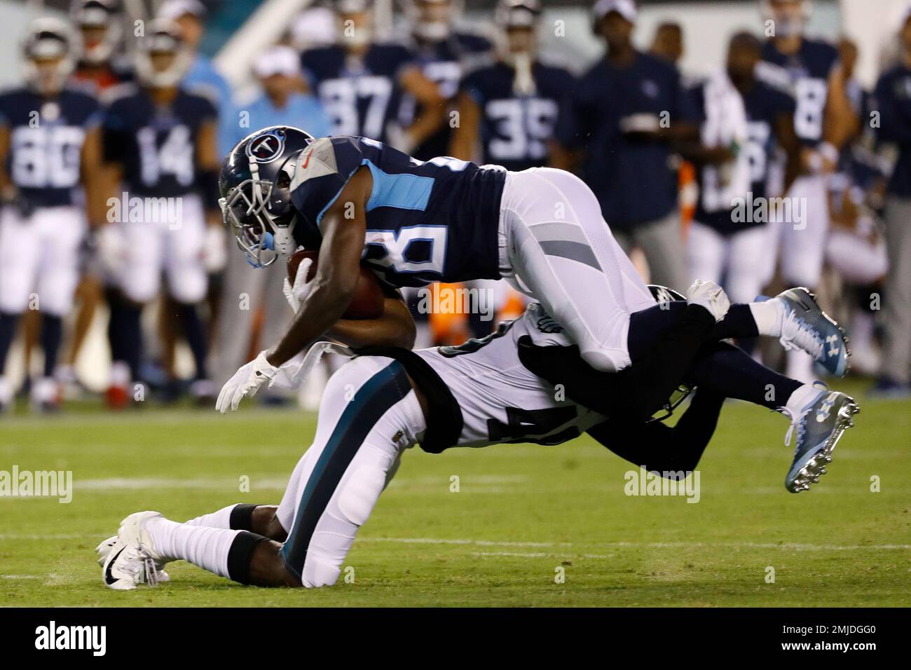 Tennessee Titans' Dalyn Dawkins, top, is tackled by Philadelphia Eagles'  Josh Hawkins during the second half of a preseason NFL football game,  Thursday, Aug. 8, 2019, in Philadelphia. (AP Photo/Michael Perez Stock