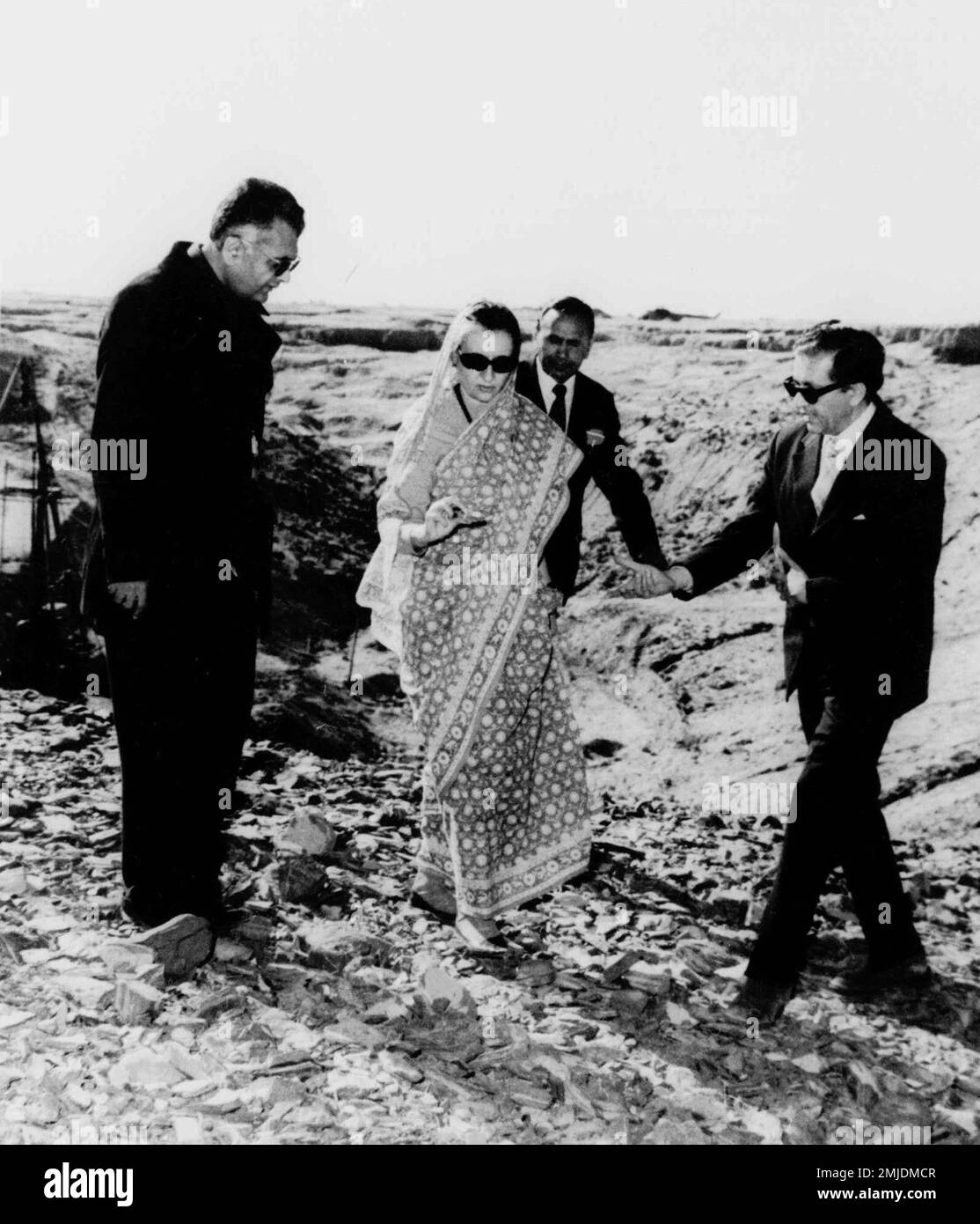 In this Dec. 22, 1974, file photo, Indian Prime Minister Indira Gandhi,  center, examines a piece of rock at the nuclear test site in Pokhran,  southeastern India. Gandhi is flanked at left