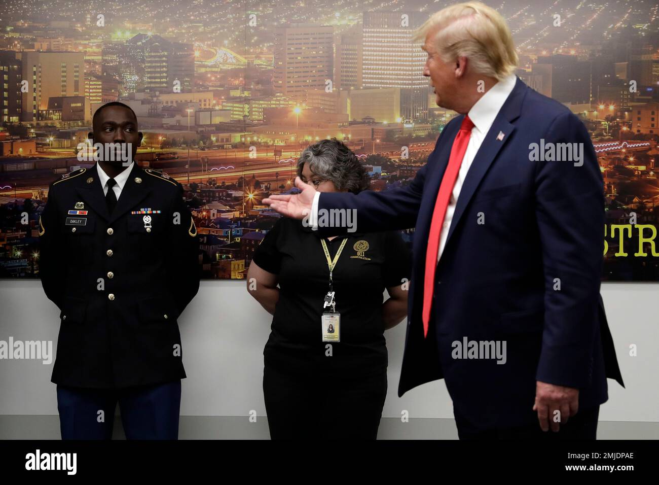 President Donald Trump gestures to Army Pfc. Glendon Oakley, left, as he  speaks to the media as he visits the El Paso Regional Communications Center  after meeting with people affected by the