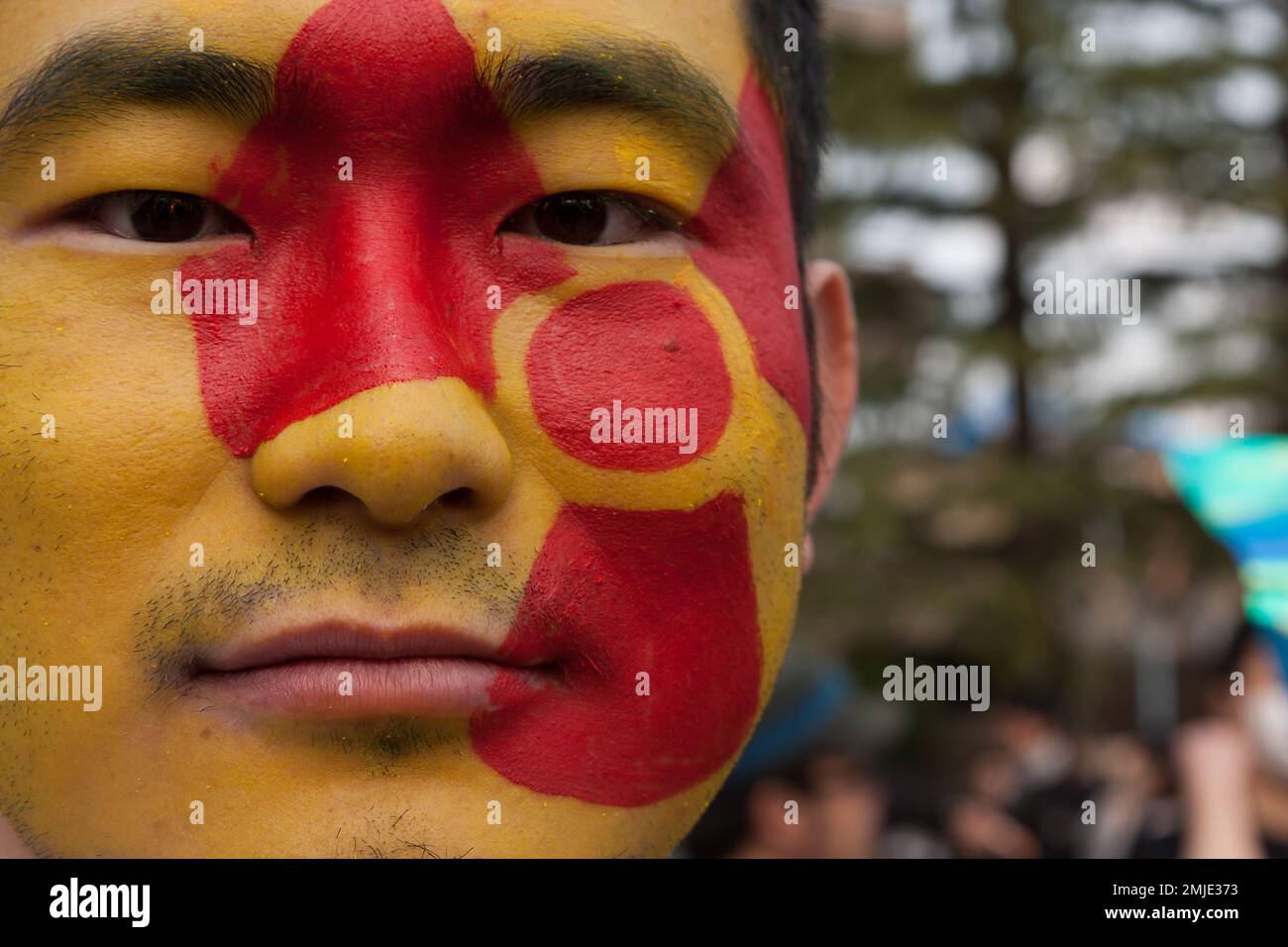 A Japanese man with a radioactive symbol painted on his face a an anti-nuclear power protest in Koenji, Tokyo, Japan. Stock Photo