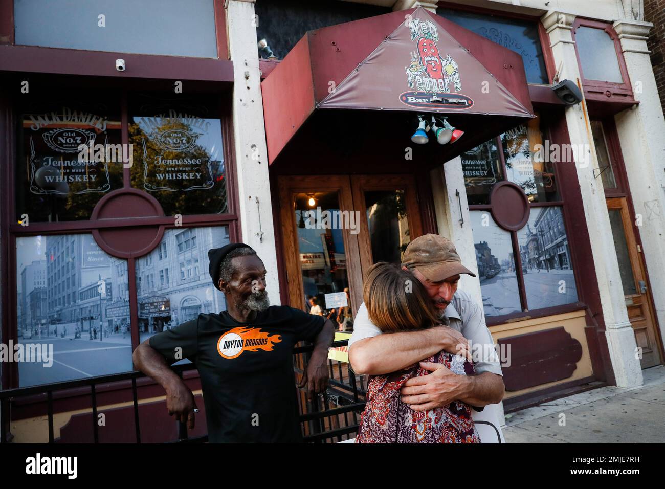 Mourners hugs at the front of Ned Peppers bar while they gather at the