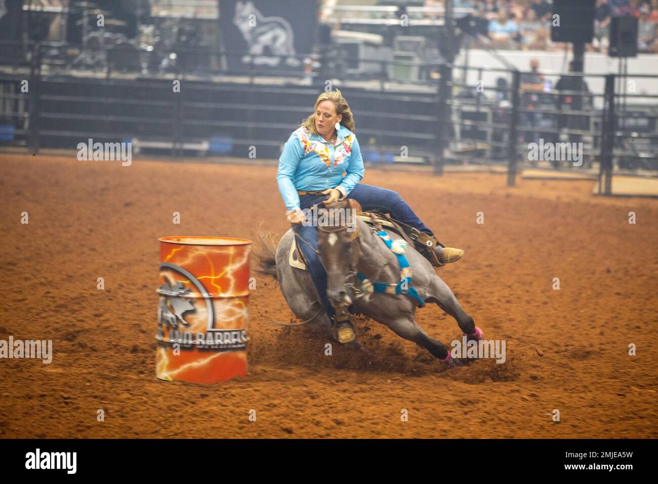 A professional rider and her horse attempt barrel racing during the