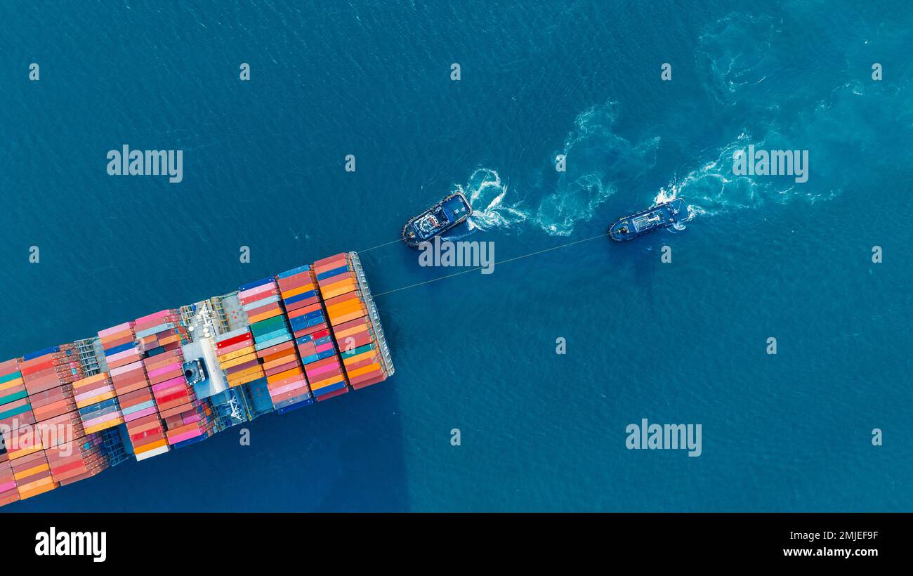 Tub Boat with Stern of cargo ship carrying container and running for