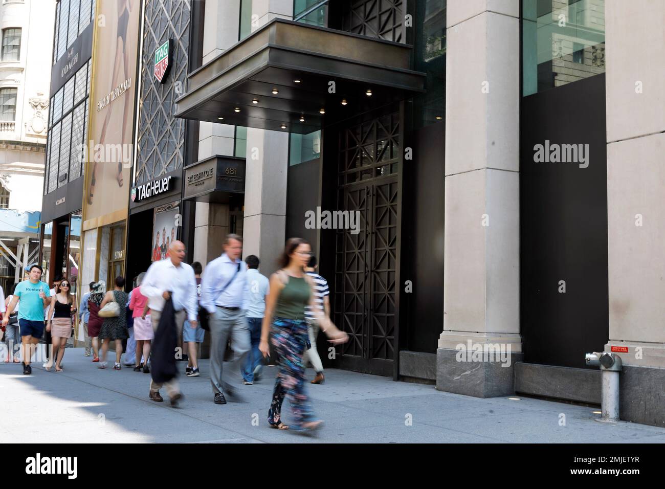 People pass the former Tommy Hilfiger store, right, on New York's Fifth  Avenue, Tuesday, July 30, 2019. Over the last year or so, Gap, Tommy  Hilfiger, Lord & Taylor and Polo Ralph