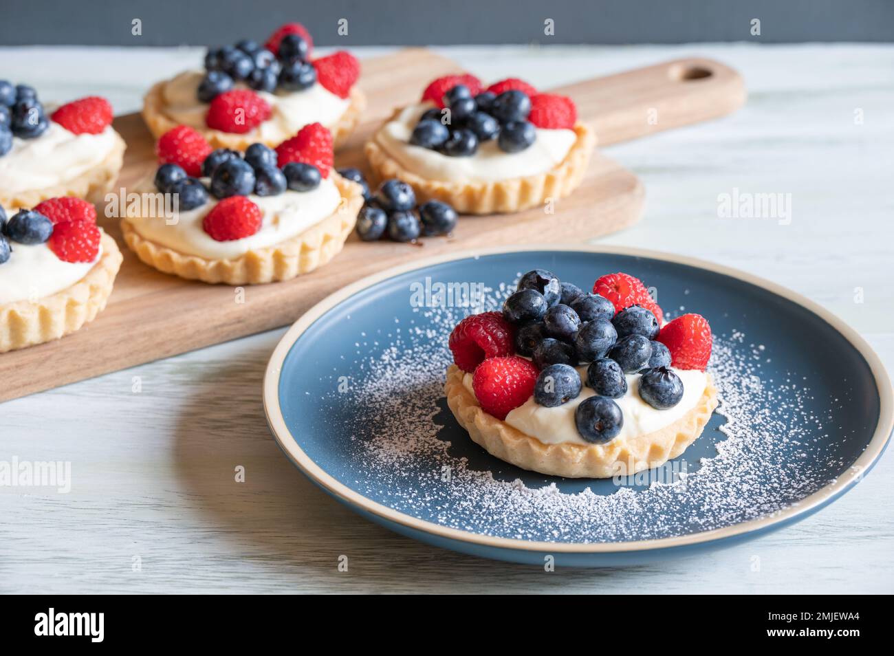 An assortment of raspberry and blueberry vanilla custard tarts Stock ...