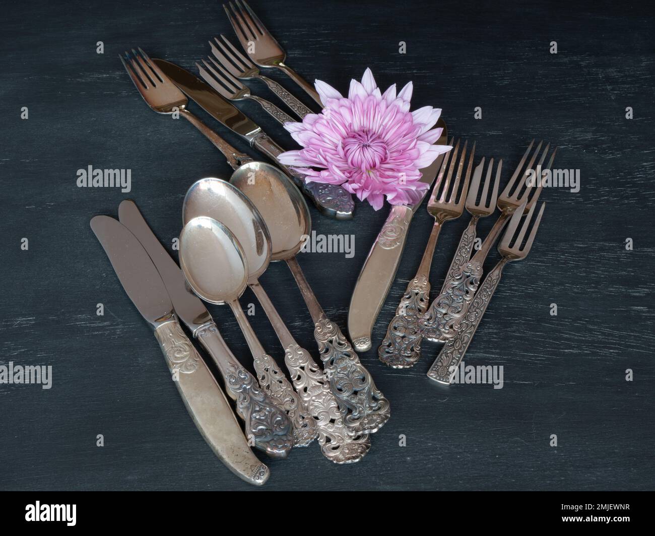 An assortment of silver spoons, knives, and forks on a table. Stock Photo
