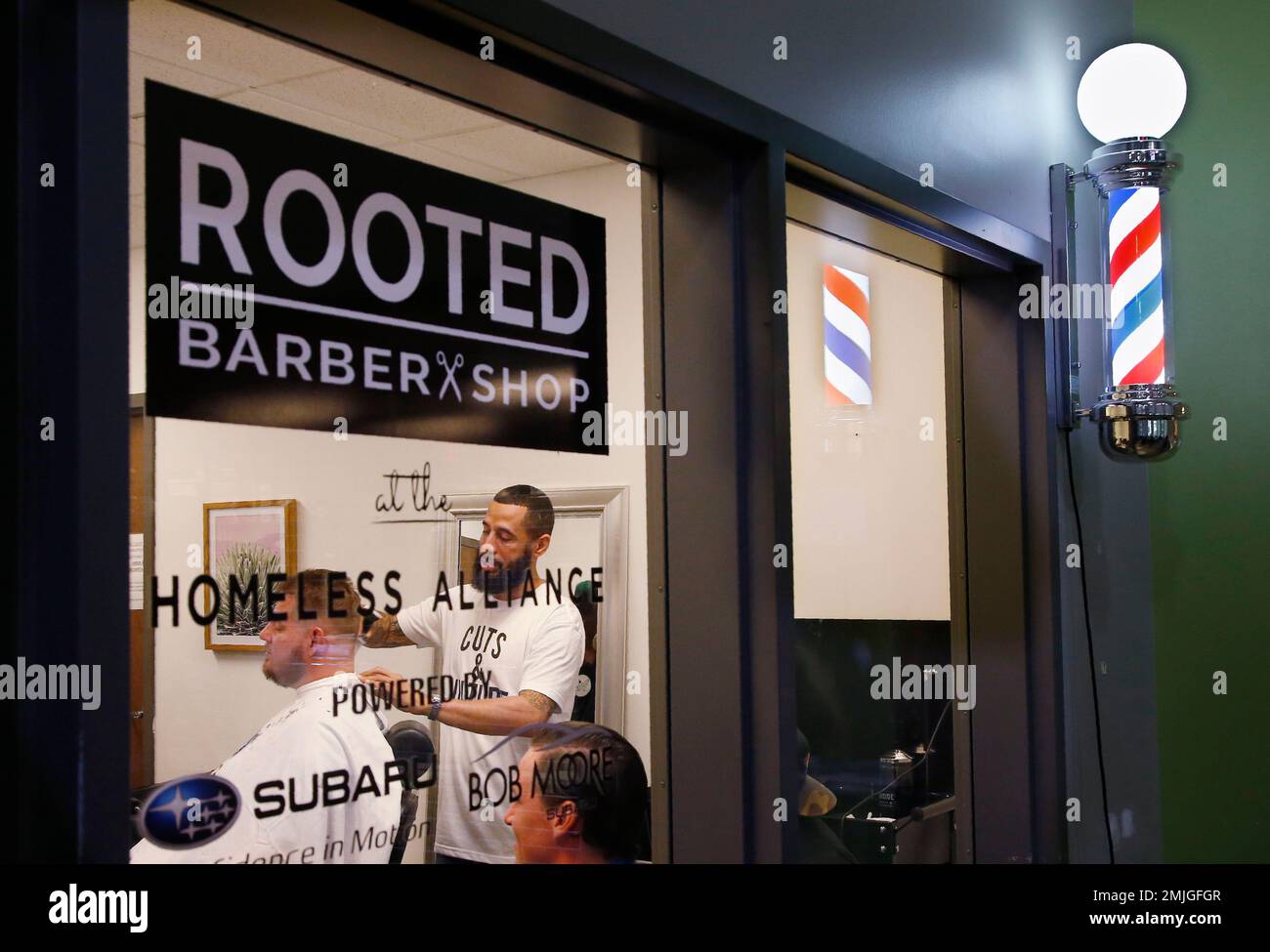 Bruce Waight, right, owner of Rooted Barber + Shop, works on client Larry  Guinn, left, on opening day at his new location at the Homeless Alliance  Day Shelter Monday, July 22, 2019,