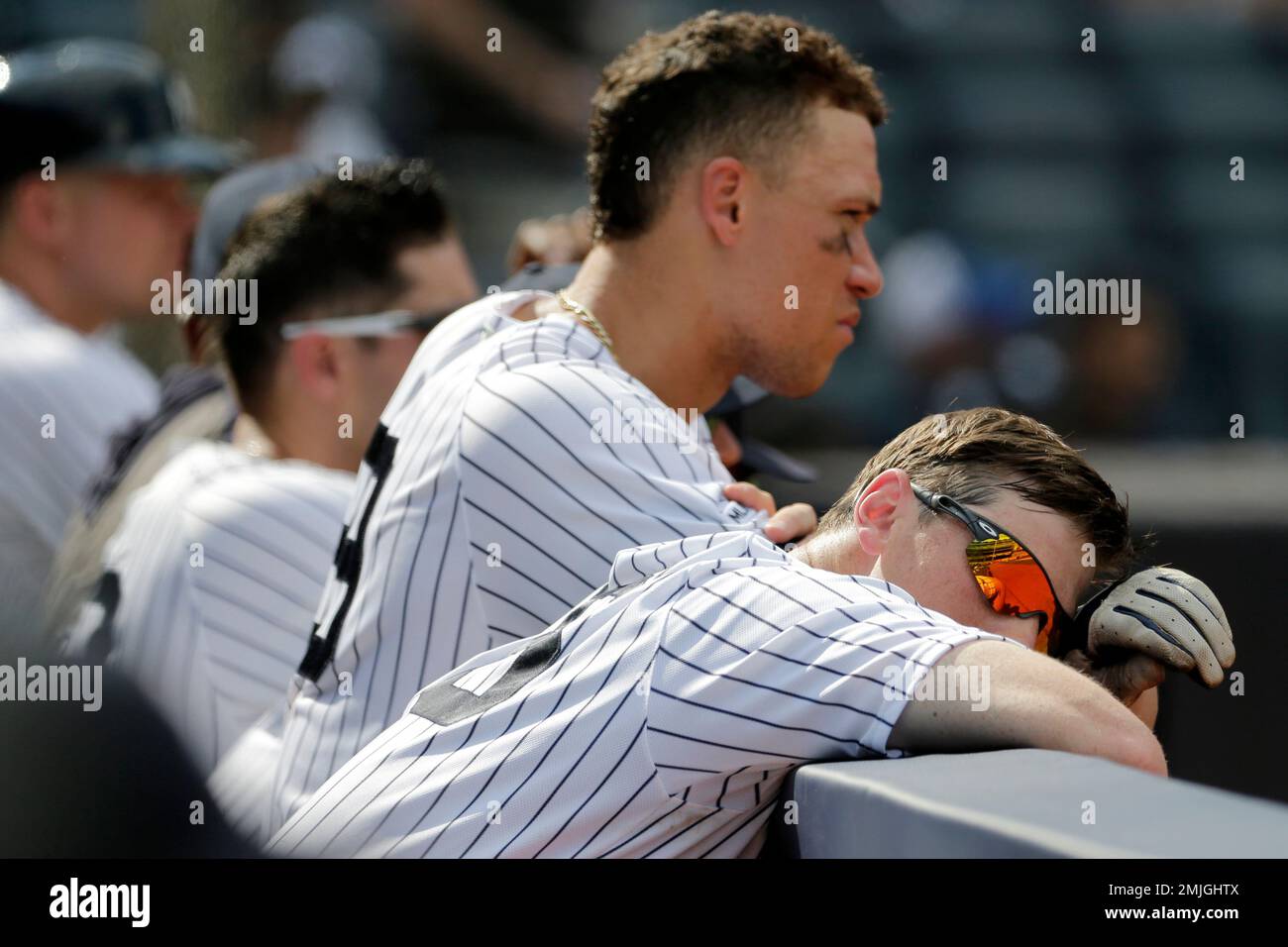 New York Yankees' DJ LeMahieu, right, leans his head on the dugout