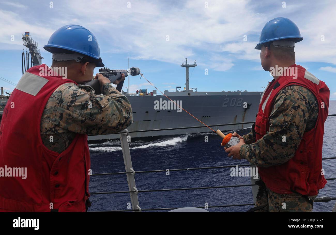 PHILIPPINE SEA (Aug. 29, 2022) – Cpl. Alfredo Moreno (left), from Dallas, and Chief Warrant Officer 2 Thach McGovern, from Fontana, California, prepare to fire a shot line from aboard Arleigh Burke-class guided-missile destroyer USS Barry (DDG 52) during an underway replenishment with Henry J. Kaiser-class underway replenishment oiler USNS Yukon (T-AO 202) while operating in the Philippine Sea, Aug. 29. Barry is assigned to Commander, Task Force 71/Destroyer Squadron (DESRON) 15, the Navy’s largest forward-deployed DESRON and the U.S. 7th Fleet’s principal surface force. Stock Photo
