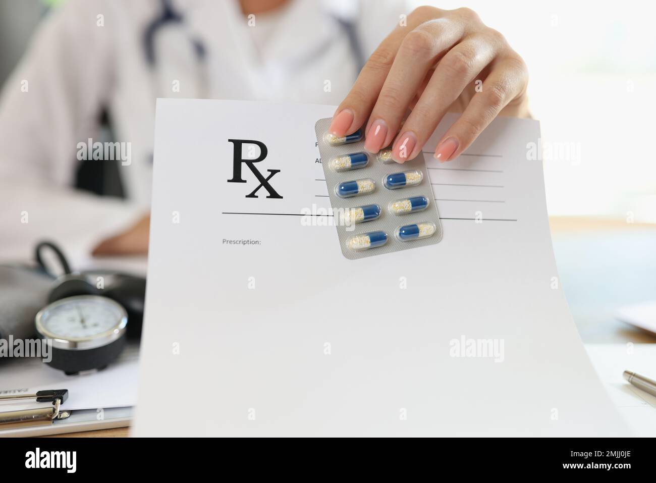 Female doctor shows blank prescription paper and medical pills. Stock Photo
