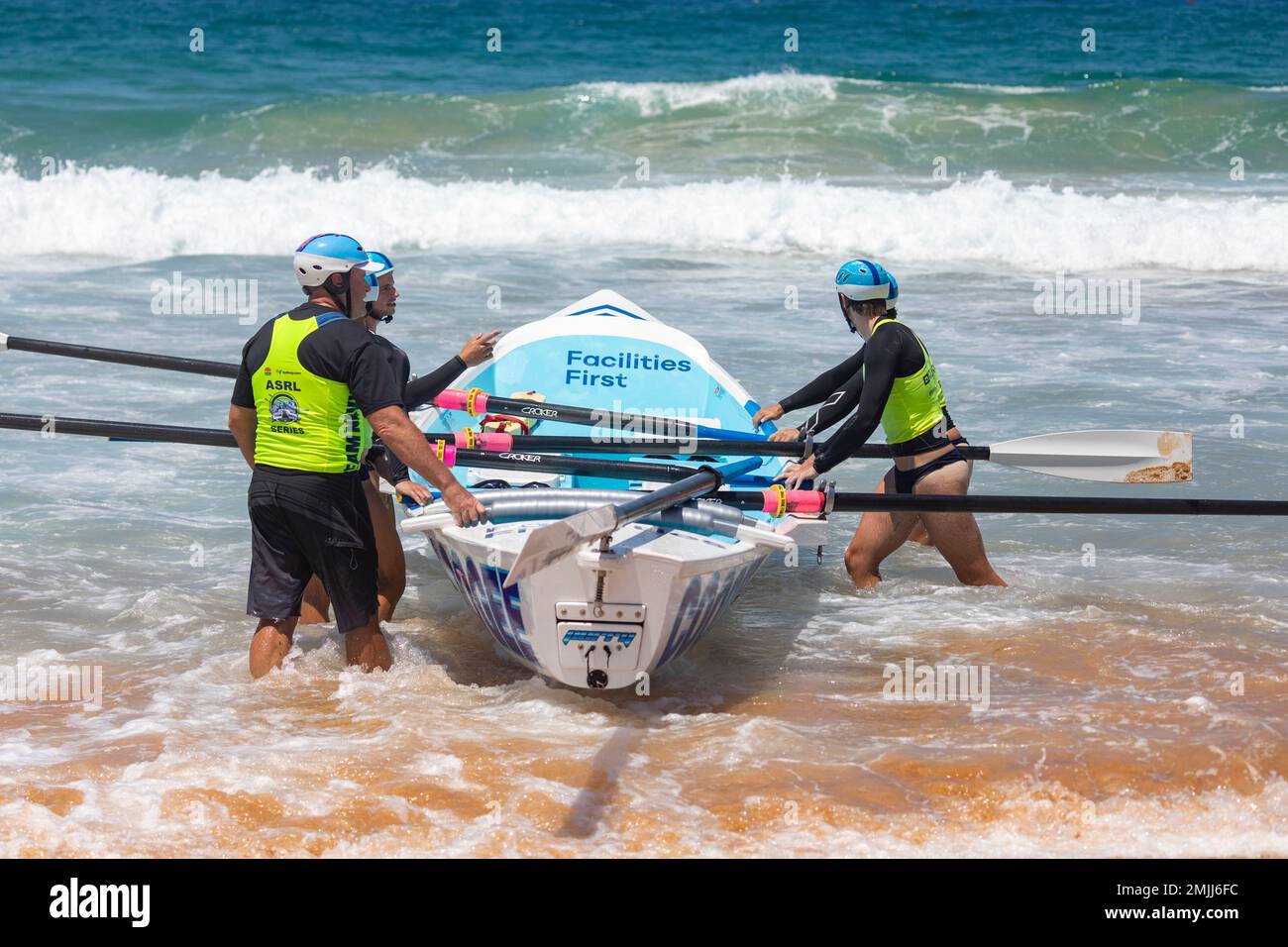 Australian traditional surfboat racing carnival 2023, male team crew awaits their sweep and start of race heat, Narrabeen,Sydney,Australia Stock Photo
