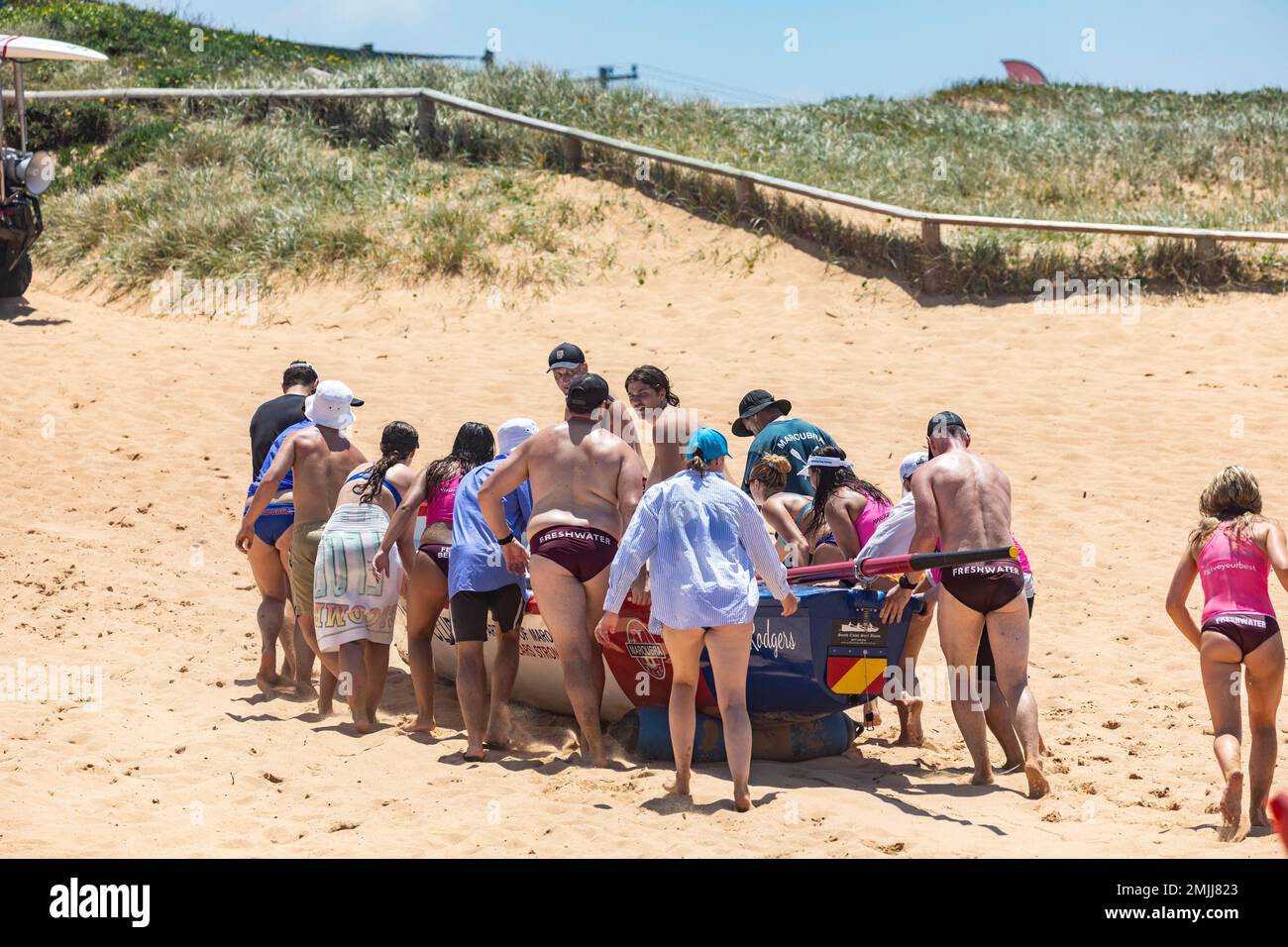 Lifting traditional surfboat across the sand at end of ocean racing,Sydney,NSW,Australia Stock Photo