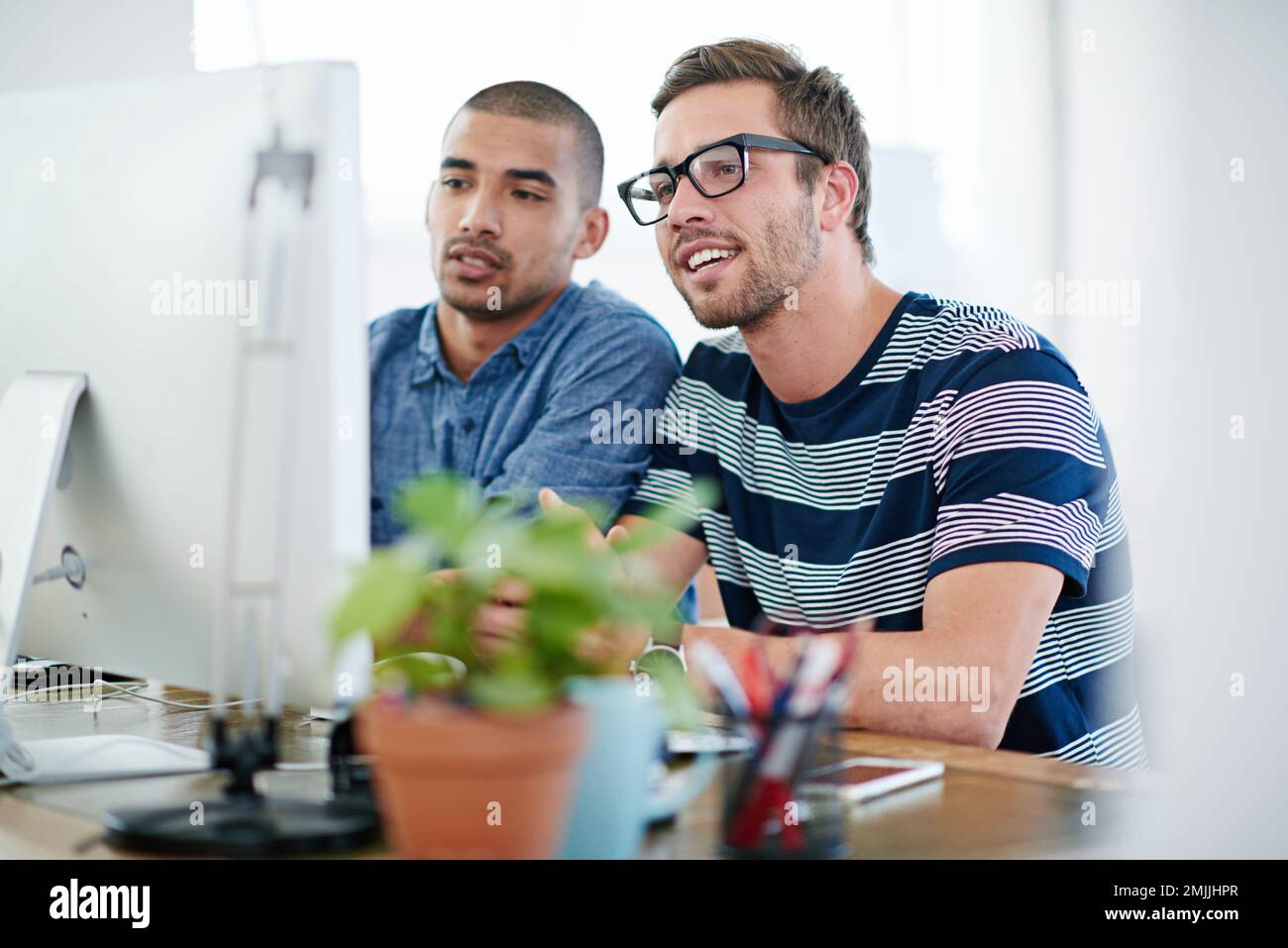 Making every detail perfect. two male designers working together at a computer. Stock Photo