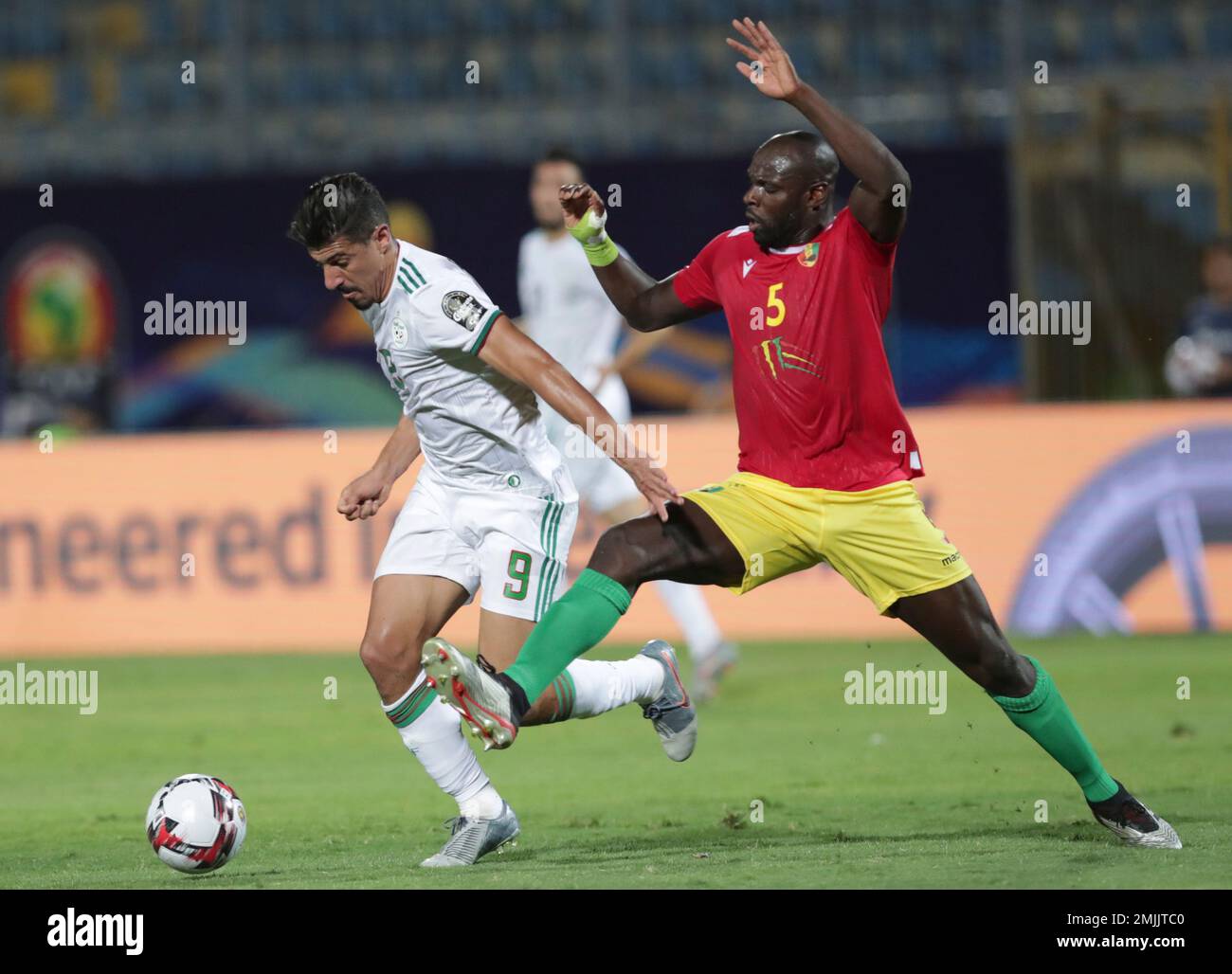 Algeria s Baghdad Bounedjah left and Guinea s Ernest Seka fight for the ball during the African Cup of Nations round of 16 soccer match between Algeria and Guinea in 30 June stadium in