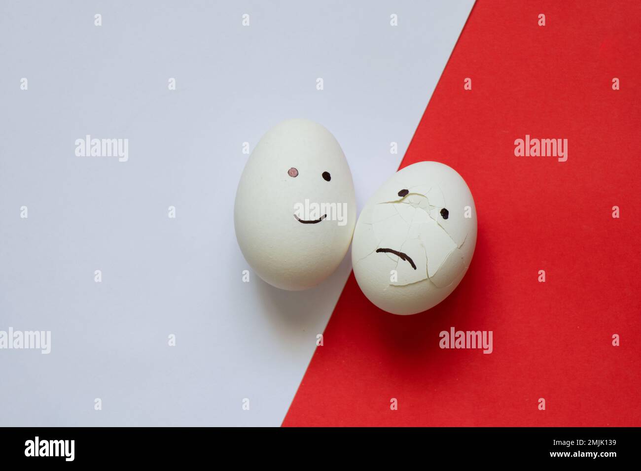 sad and joyful chicken egg on a colored background Stock Photo