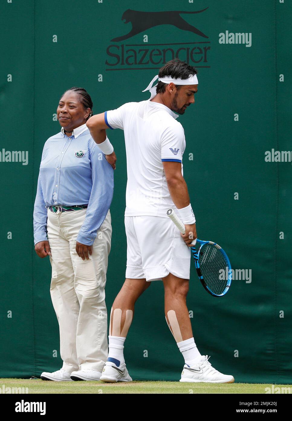 Italy's Fabio Fognini pats a line judge on the shoulder as he plays United  States' Tennys Sandgren in a Men's singles match during day six of the  Wimbledon Tennis Championships in London,