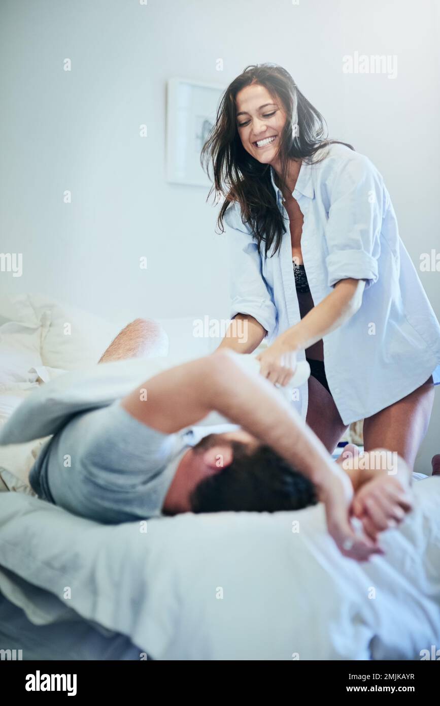 This should get you up...a young couple enjoying a pillow fight in their bedroom. Stock Photo