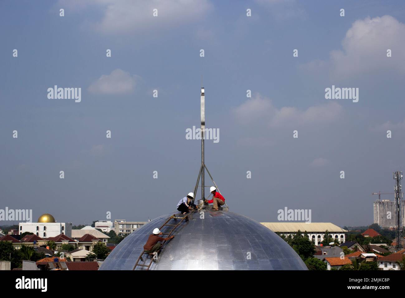 Three workers repaired the dome of the mosque Stock Photo