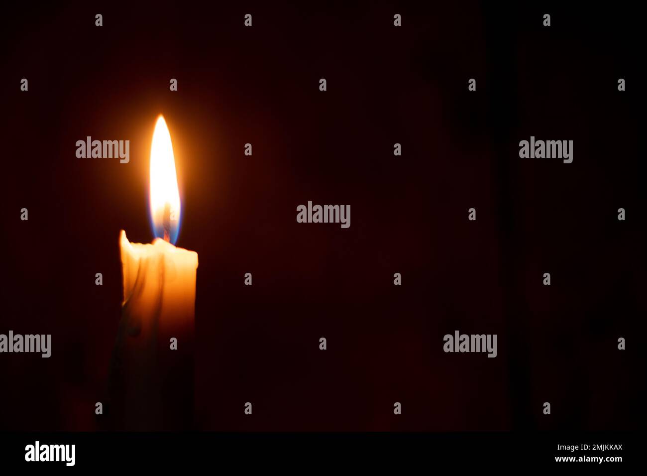 single candle flame in the dark as a background Stock Photo