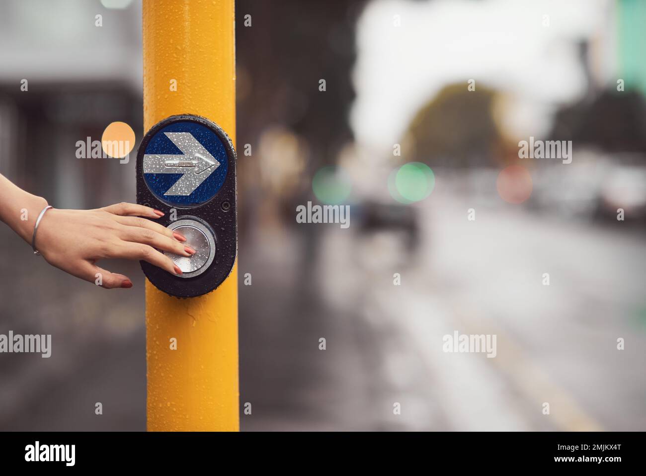 Crossing safely. Closeup shot of a woman pressing a button at a cross walk. Stock Photo