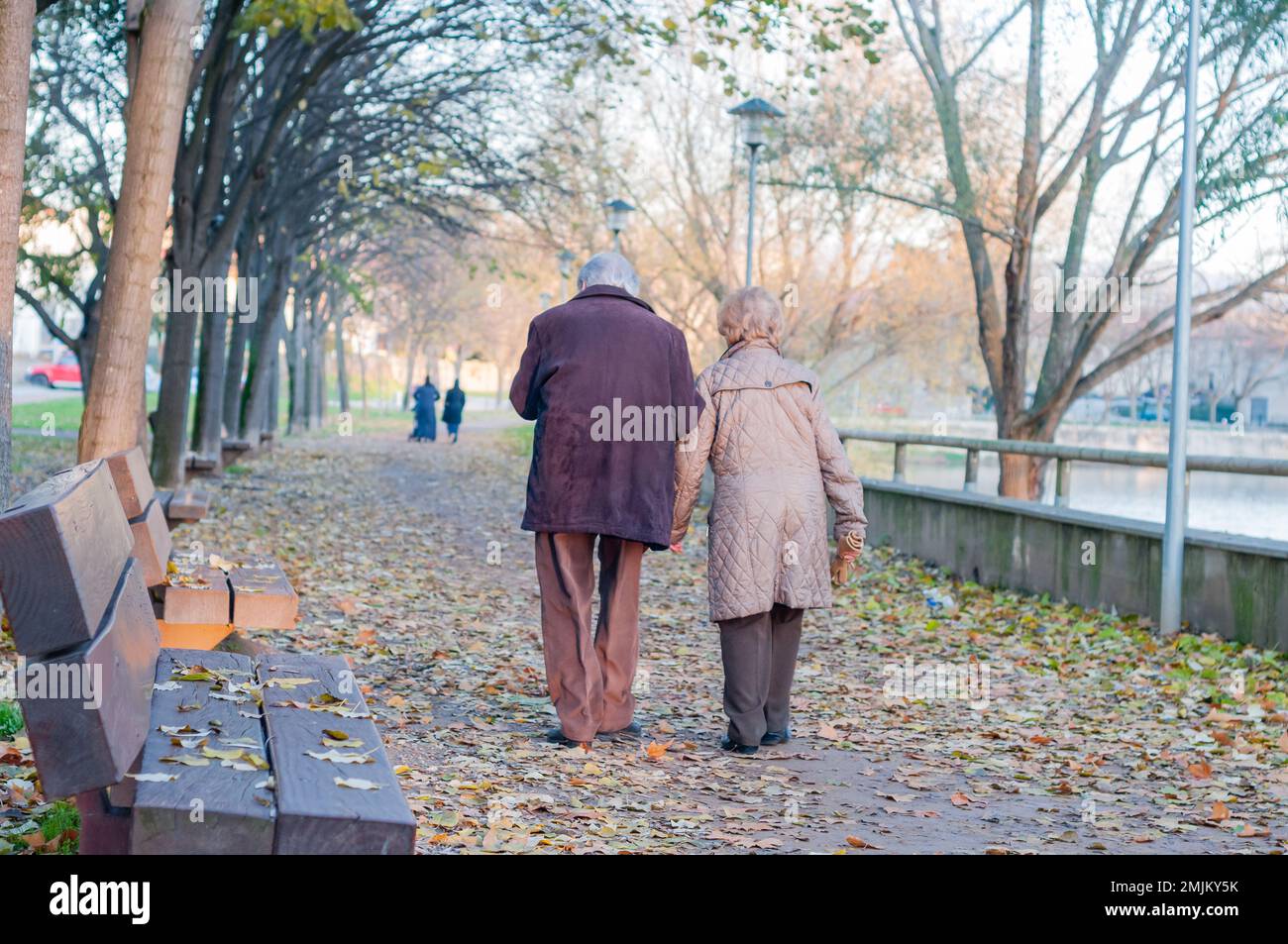 Elderly couple walking along a pedestrian street next to the river, Manlleu, Catalonia, Spain Stock Photo