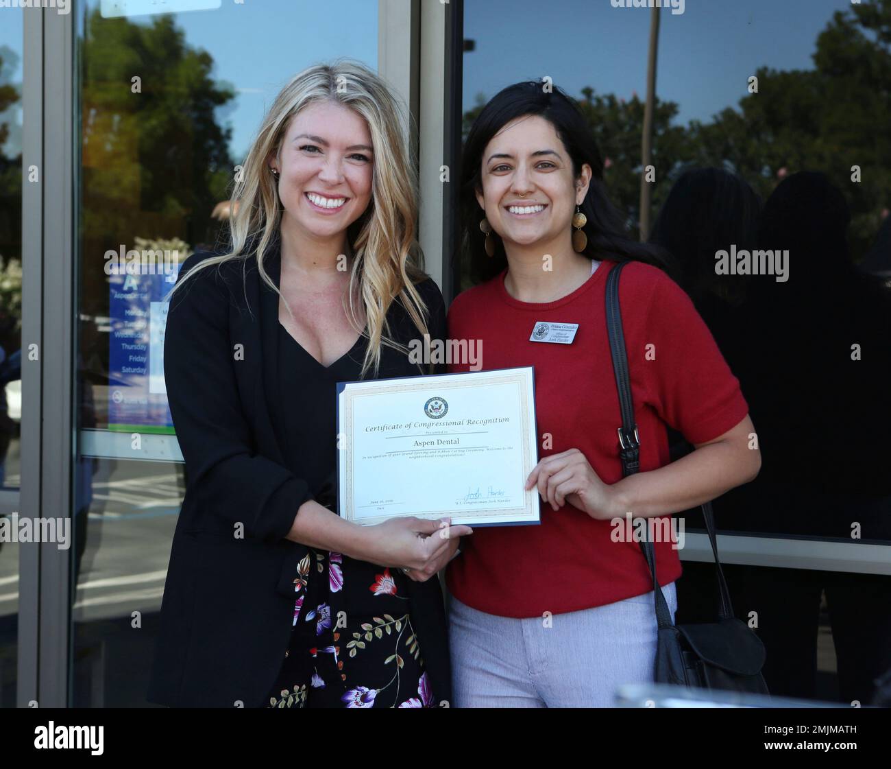 Courtney Williamson, left, of Aspen Dental, accepts a resolution from