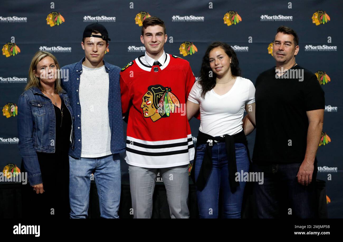Chicago Blackhawks' first round draft pick Kirby Dach, center, poses for a photo with this