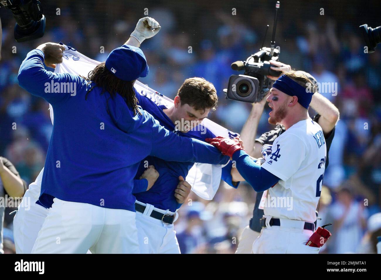 Los Angeles Dodgers' Will Smith, center, has his shirt ripped off by Kenley  Jansen, left, and Alex Verdugo after hitting a two-run walkoff home run  during the ninth inning of a baseball