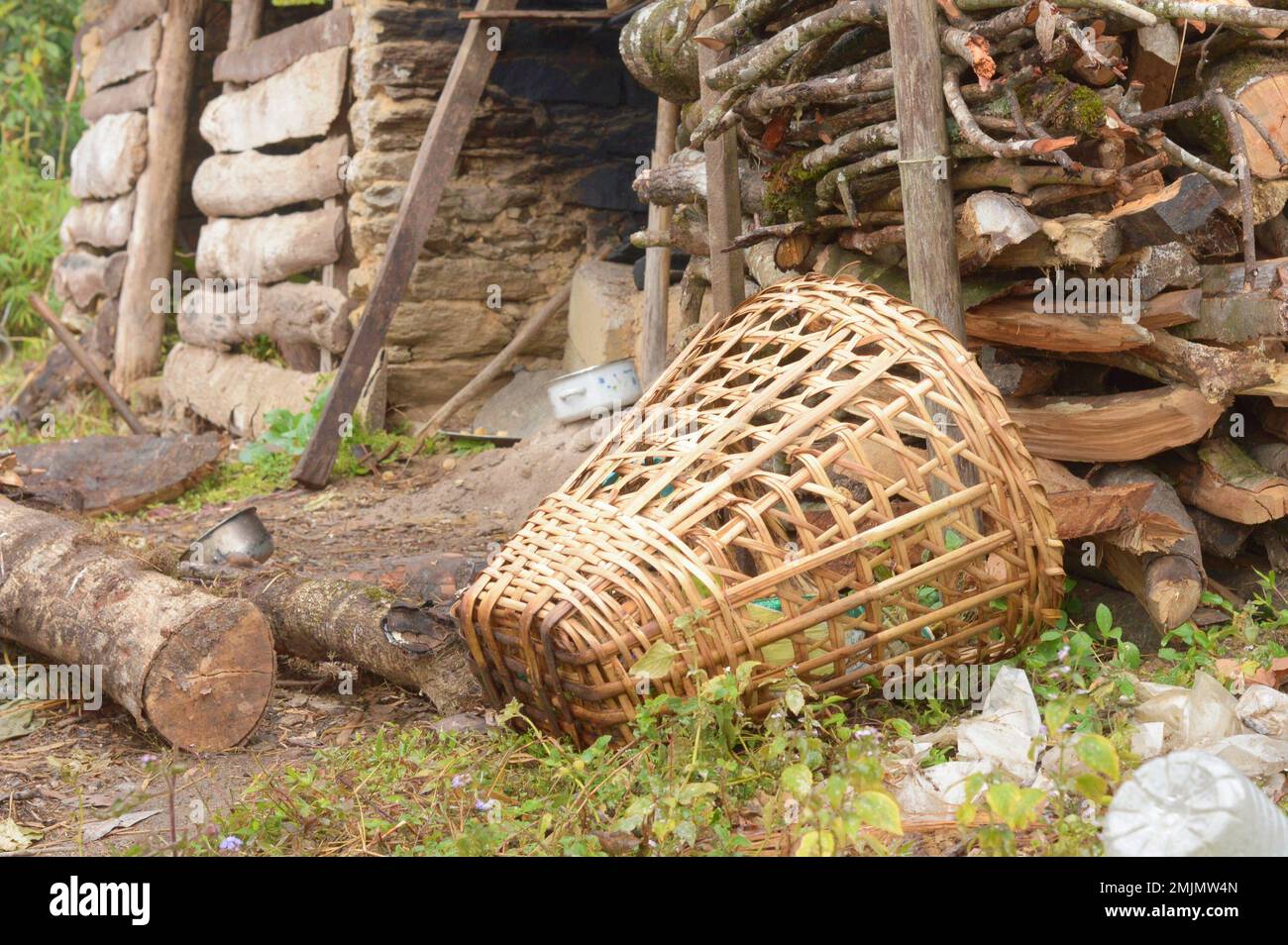 A Bamboo Basket laying in front of firewood storage room. Tabakoshi Rangbang, Mirik, West Bengal India . Stock Photo