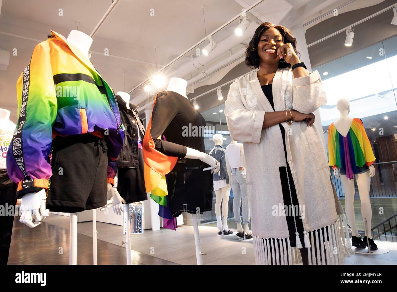 In this June 4, 2019, photo Ezinne Kwubiri, H&M's Head of Diversity and  Inclusion, North America, poses with items in the company's Pride OUT Loud  collection, in their New York headquarters. Kwubiri
