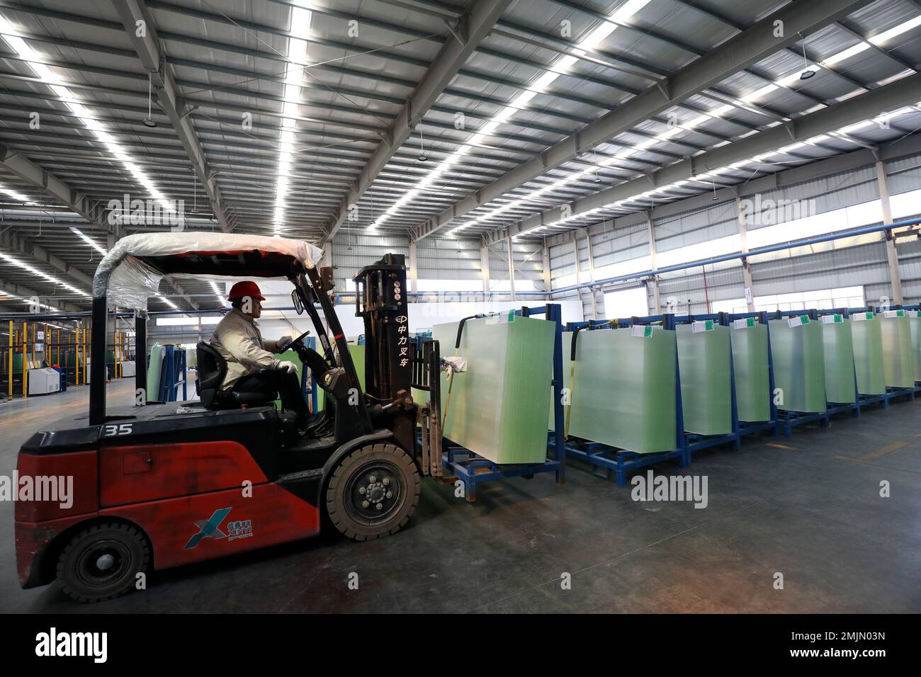 CHENZHOU, CHINA - JANUARY 28, 2023 - A worker works at a workshop of high-permeability substrate materials for photovoltaic modules at Qibin Photovolt Stock Photo