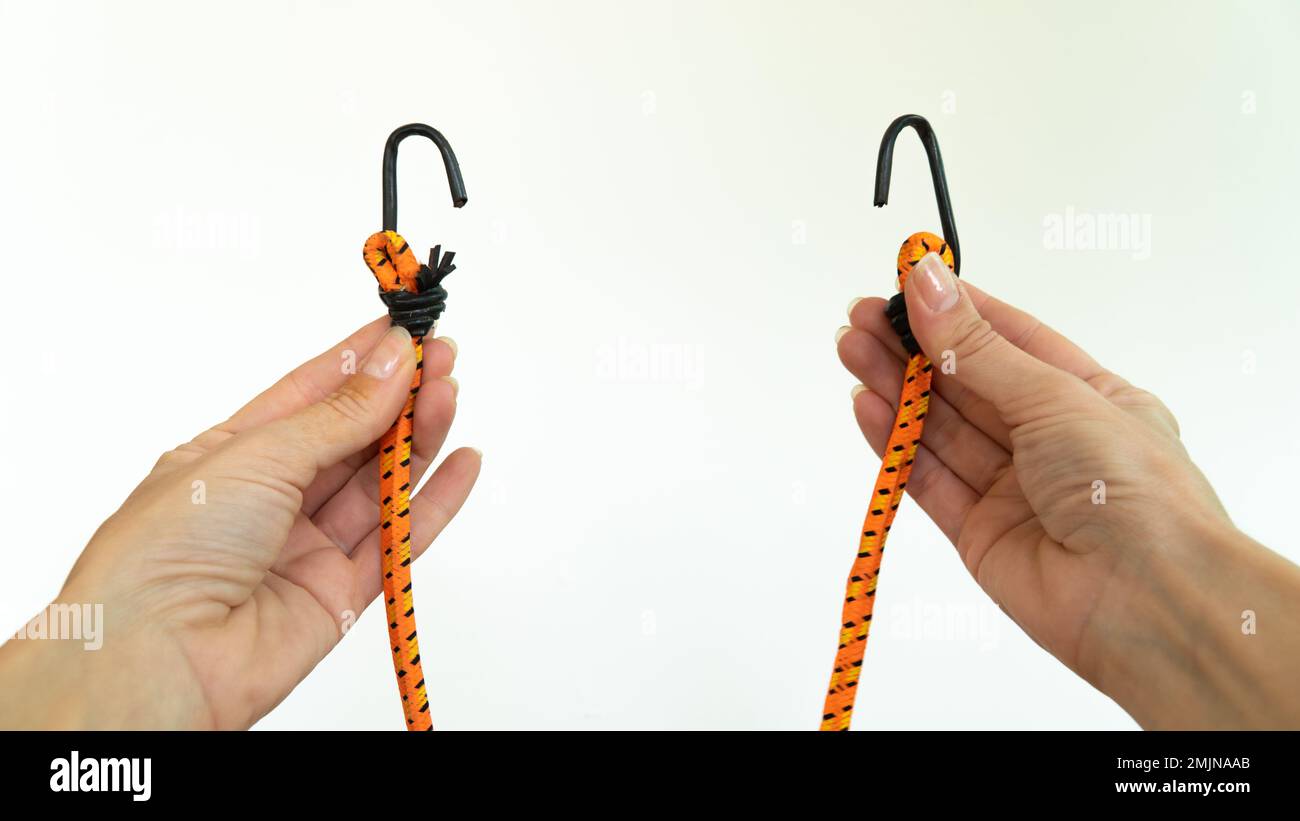 Hands hold luggage rack, rubber band with hooks Stock Photo Alamy