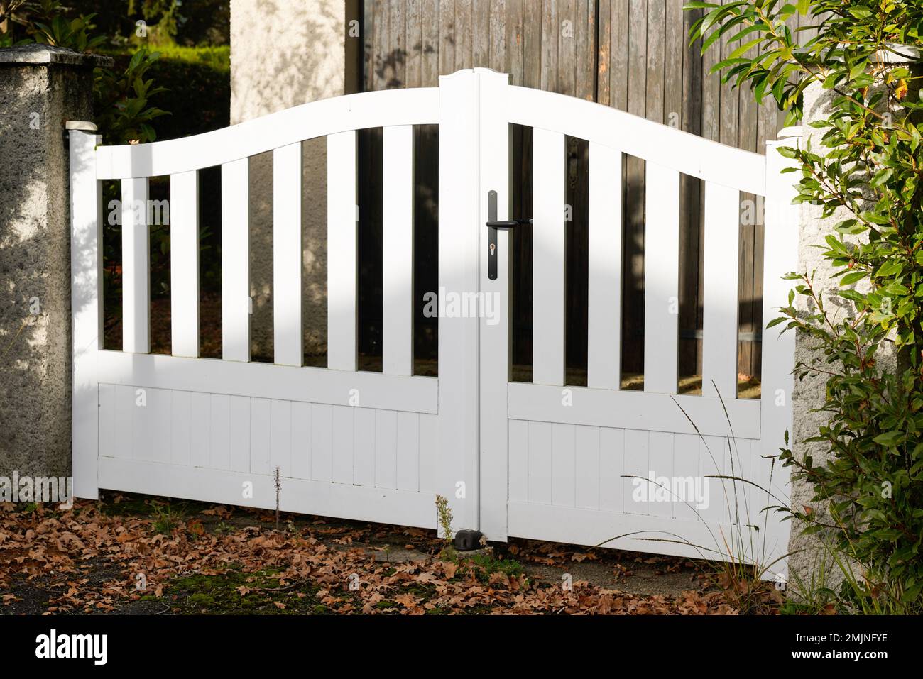 suburban steel metal gate white fence of home suburb street access house garden Stock Photo