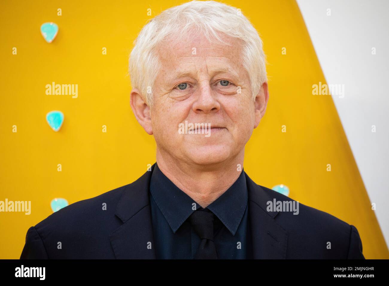 Screenwriter Richard Curtis poses for photographers upon arrival at the