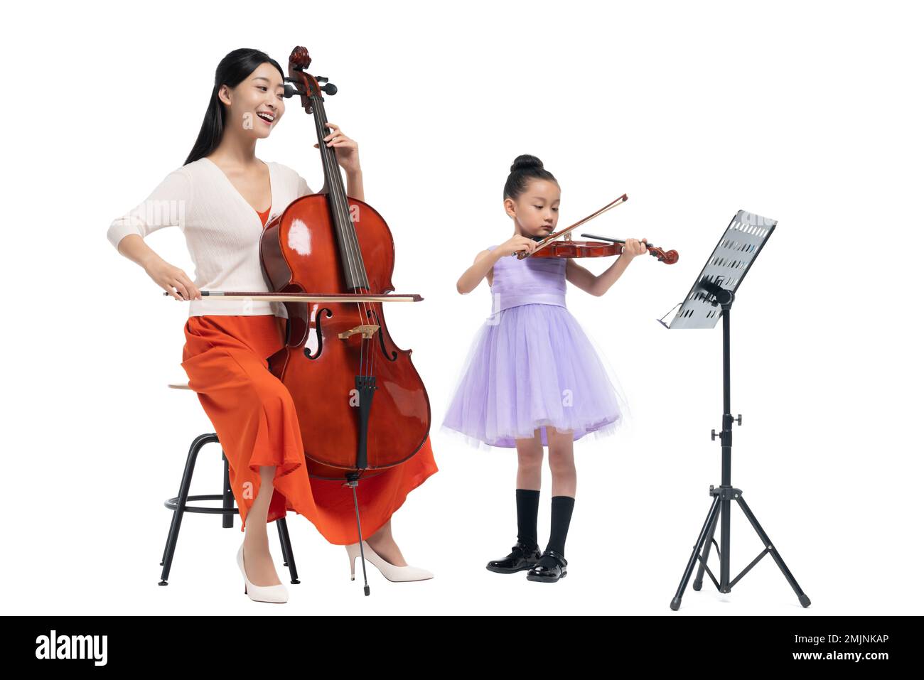 The female teacher guide girl playing Musical Instruments Stock Photo ...