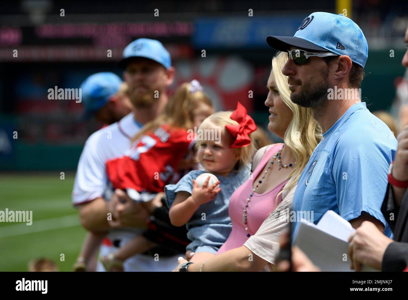 Washington Nationals' Max Scherzer and his wife Erica, second from right,  holding their daughter Brooklyn, stand on the field before a baseball game  against the Arizona Diamondbacks, Sunday, June 16, 2019, in