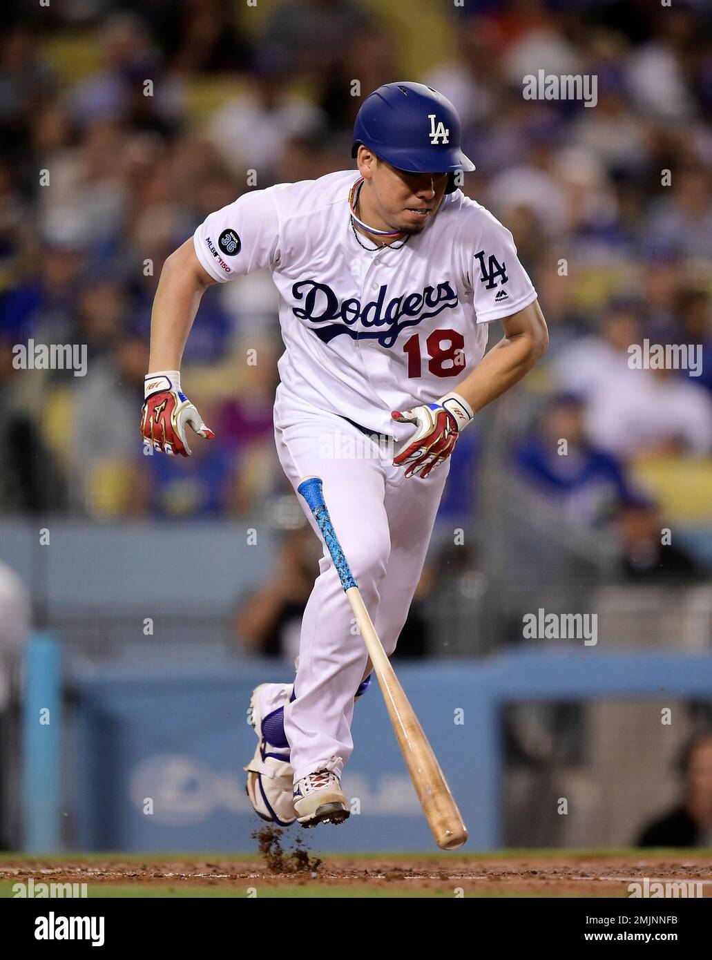 Los Angeles Dodgers' Kenta Maeda, of Japan, raises his glove after making a  catch in center field during batting practice prior to the team's baseball  game against the Milwaukee Brewers on Tuesday