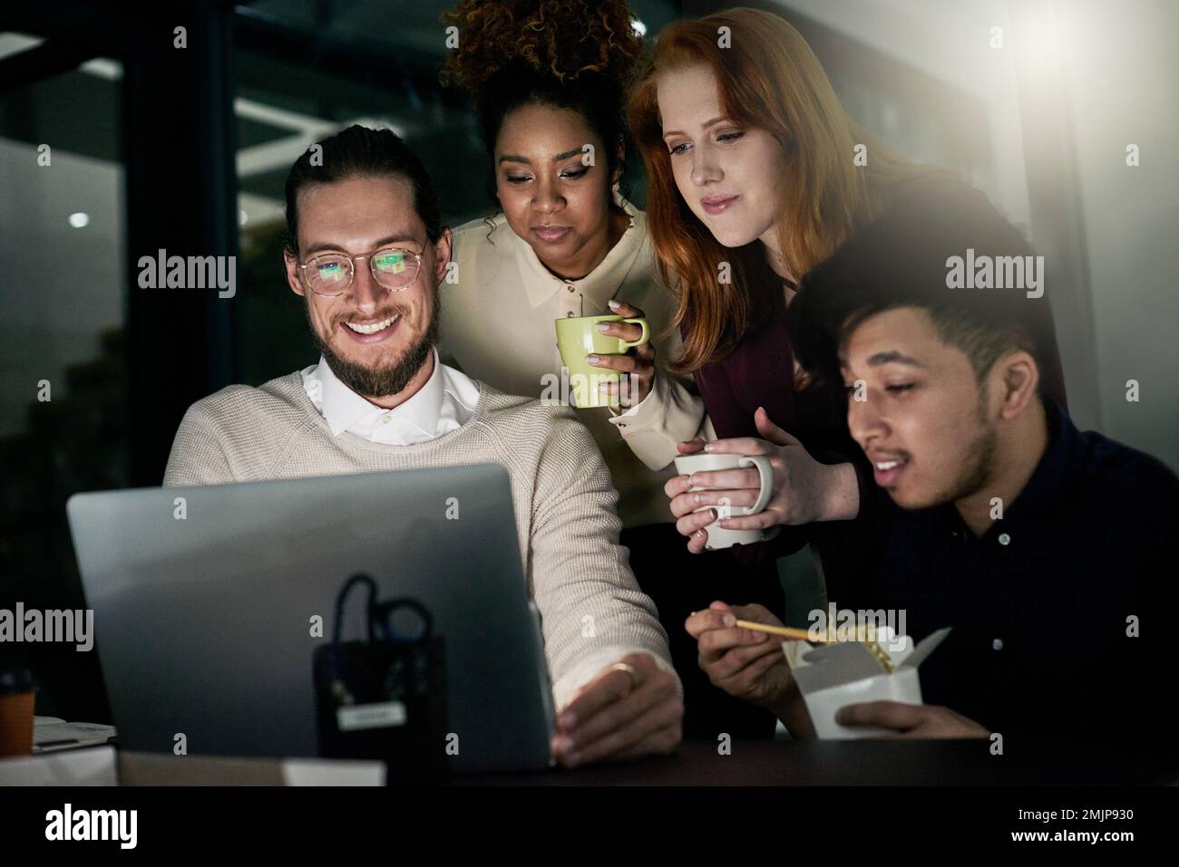 Theyre a positive group of professionals. a group of young designers working late in the office. Stock Photo