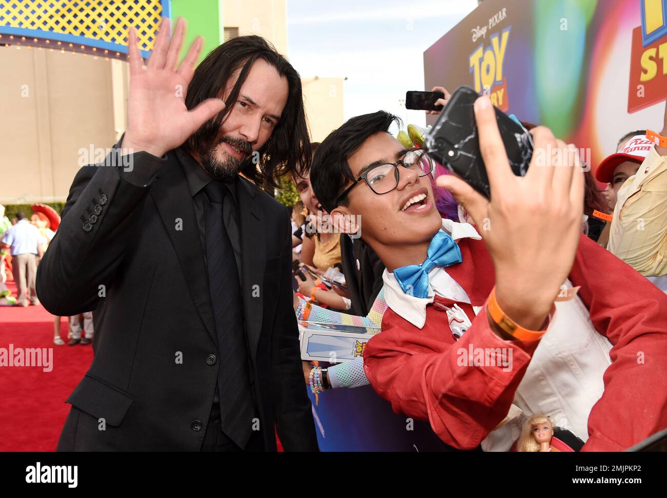 Keanu Reeves left a voice cast member in Toy Story 4 poses for a photo with a fan at the premiere of the film at the El Capitan Theatre Tuesday June 11