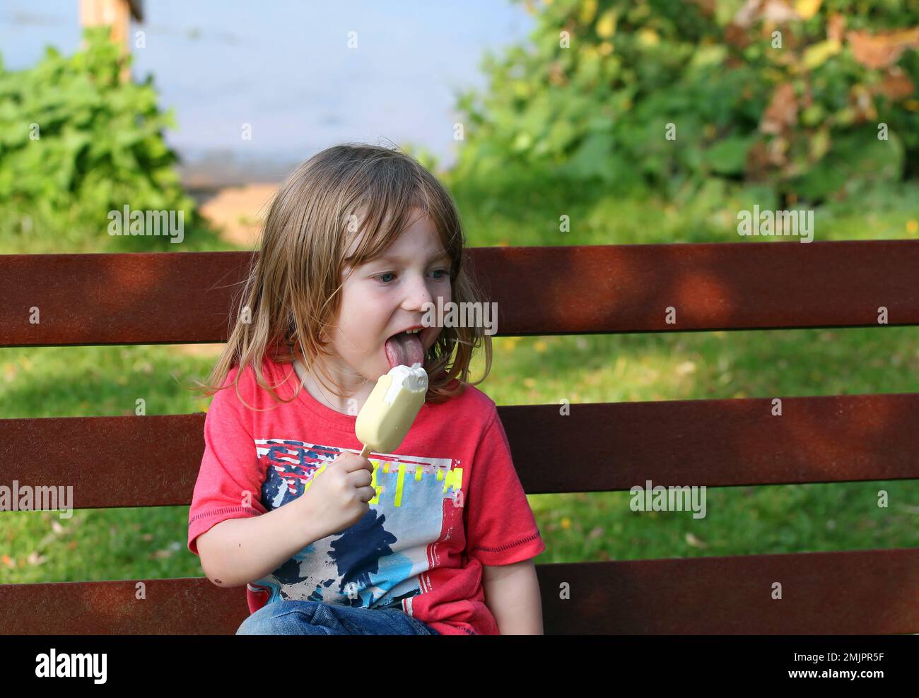 Young child happily eating an ice cream. Stock Photo