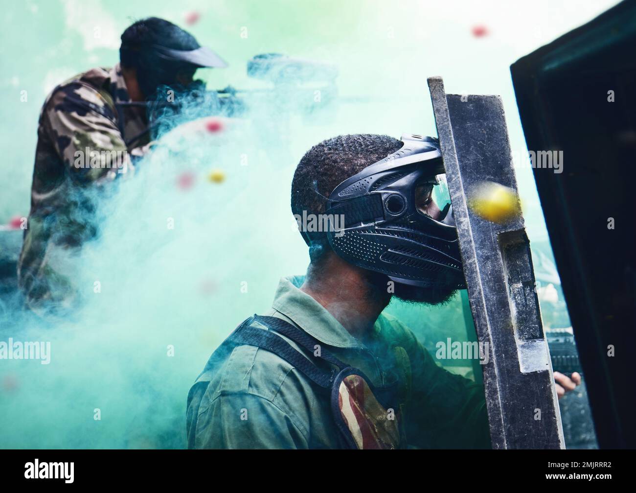 Paintball team, shooting together and war game with shield, mask or