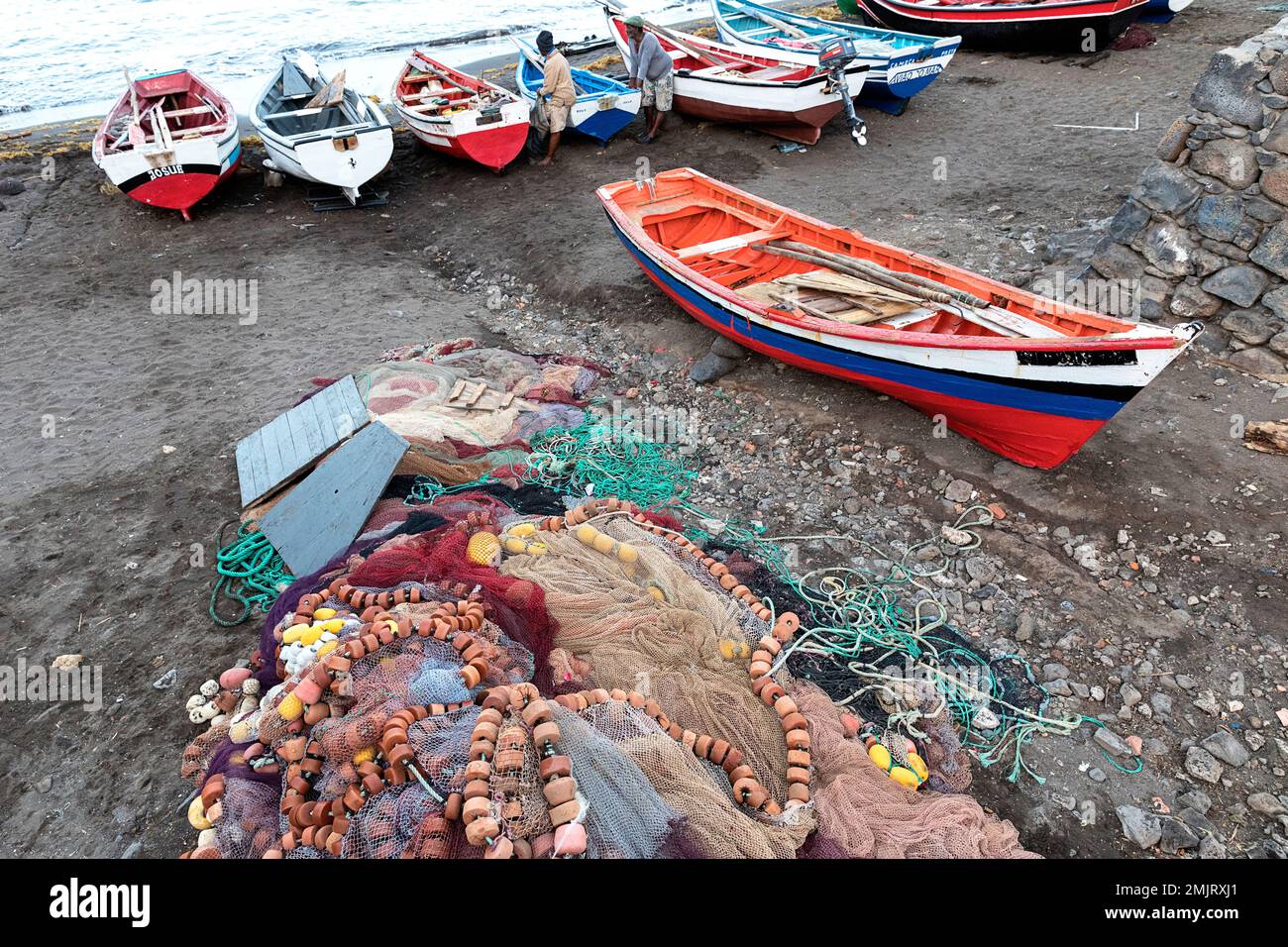 Traditional fishing wooden boats and fishing nets at the beach in Cidade Velha, Santiago island, Cabo verde, Cape verde Stock Photo